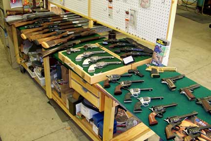 Work area showing some of the guns they work on or have for sale.